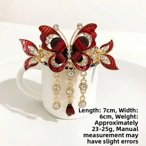 Detailed view of red butterfly hair claw with rhinestones, 7x6cm size and tassels