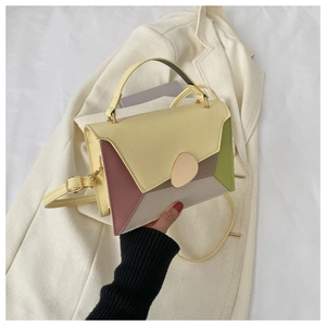 Gros plan d'un sac à main en cuir PU bicolore avec panneaux géométriques et boucle dorée
