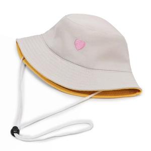 Beige and yellow reversible sun hat with pink heart embroidery and adjustable chin strap