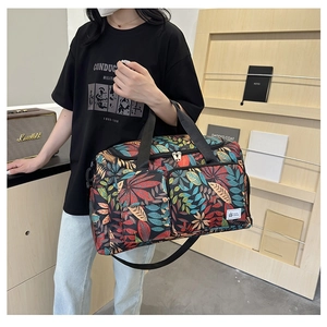 Travel tote bag featuring tropical leaf print shown with model for size reference