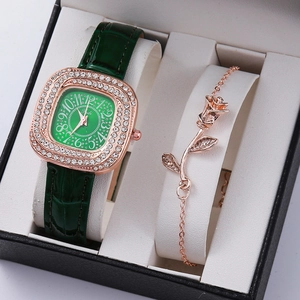 Close-up of green leather watch and rose gold bracelet set in elegant gift packaging