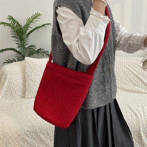 Vue détaillée de la texture pelucheuse rouge sur le grand sac seau à bandoulière