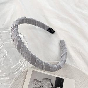 Detail of grey fabric headband with elegant pleated texture and soft sponge padding