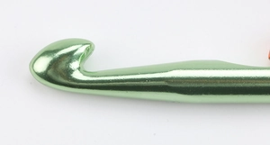 Macro shot of 15mm green alumina crochet hook head with smooth metallic finish