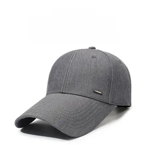 Close-up of a grey baseball cap featuring a metal fashion tag and breathable eyelets