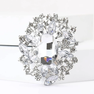 Detailansicht einer verzierten Silberbrosche mit großem Ovalkristall und Blumenrhinestones