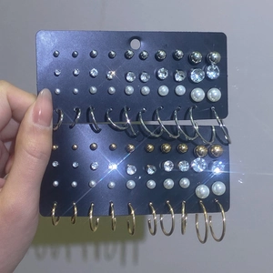 Detail of multi-style earring set with pearls and rhinestones on black display cards
