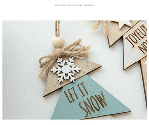 Macro shot of wooden Christmas tree ornament with Let it Snow engraving and hemp rope bow