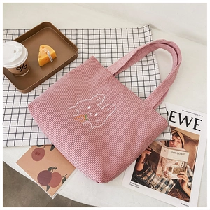 Detail of pink corduroy tote bag with cute rabbit embroidery and soft handle design