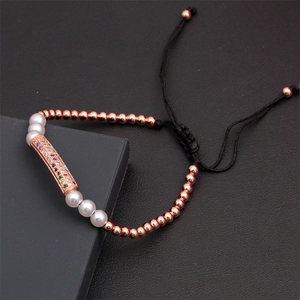 Detail of adjustable braided bracelet with rose gold beads, pearls, and colorful zircon charm