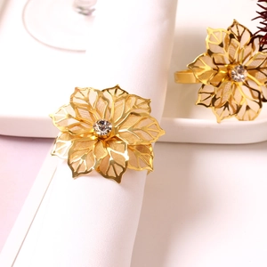 Detailansicht goldener Serviettenringe in Blumenform mit hohlen Blütenblättern