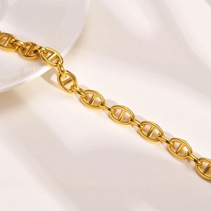 Polished 18k gold plated pig nose anchor chain bracelet on white fabric background