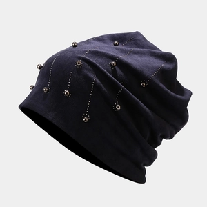 Detailed view of navy velvet beanie with sparkling rhinestones and pearl embellishments