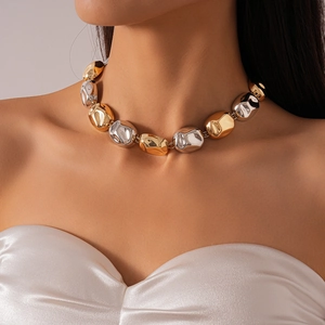 Detail of chunky gold and silver toned oval metal beads on a statement collar necklace