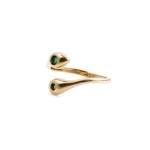 Macro detail of gold-plated snake ring with green zircon stones on white background