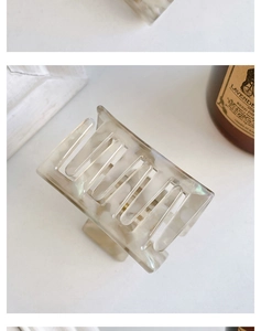 Detailed close-up of a square acetate hair claw clip with white marble texture