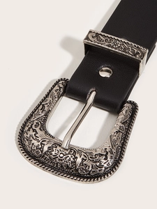 Close-up of vintage silver floral engraved buckle on classic black punk style belt