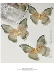 Detail of three gradient tulle butterfly hair clips with delicate pearl embellishments