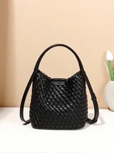 Handwoven black leather bucket bag with top handle and adjustable shoulder strap