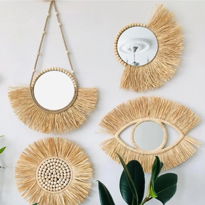 Dettagli macro di specchi da parete in rafia boho con paglia intrecciata e perline in legno