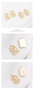 Close-up of 14K gold filled pendants with embossed butterfly and tulip floral designs