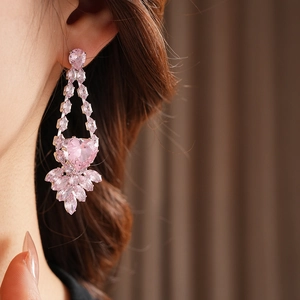 Gros plan de boucles d'oreilles cœur en zircon rose avec design gland de luxe