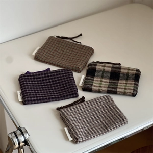 Set of four plaid wool zipper pouches in brown, purple, and green colors for storage