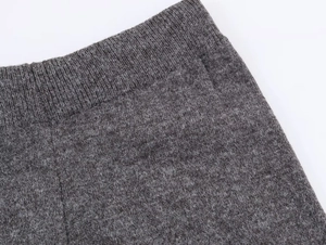Detalle de conjunto de punto gris oscuro que muestra textura de cintura y tejido acanalado
