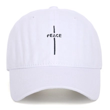 Close-up of black cross and Peace embroidery on a white vintage washed baseball cap