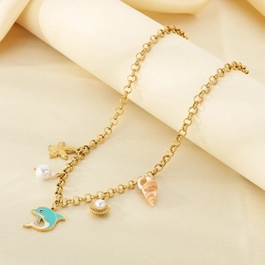 Detail of gold starfish, shell, and blue dolphin pendants on a pearl beach anklet