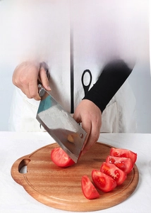 Macro detail of the round wooden cutting board showing the food-grade olive oil coating
