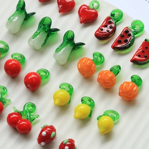 Macro shot of colorful glass fruit charms with metal loops for DIY jewelry making