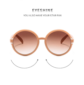 Detail of round light brown sunglasses with gradient lenses and silver metal hinges