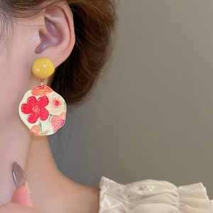 Detail of French oil painting style sunflower drop earrings with artistic floral enamel
