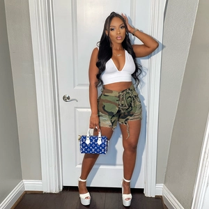Détail du short en jean camouflage avec bords effilochés et design déchiré usé
