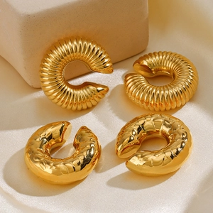 Boucles d'oreilles en C dorées 18K lisses et texturées sur un tissu en soie