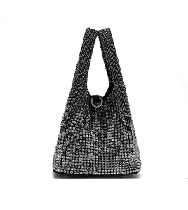Close-up of sparkling silver rhinestone bucket bag with shiny metallic D-ring buckle