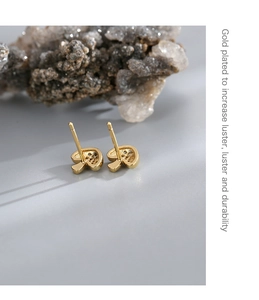 Detail of gold-plated mushroom studs featuring white zircon micro-inlay and hollow design