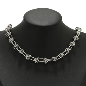 Polished silver stainless steel knot chain necklace on a black mannequin display