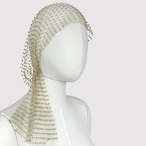 Close-up of champagne gold mesh headpiece with shimmering crystal beads on mannequin