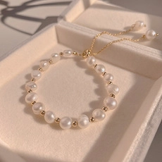 Detailed view of elegant pearl bracelet with gold beads in a soft velvet jewelry box