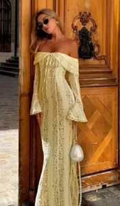 Detail of elegant yellow lace dress showing off-shoulder neckline and bell sleeves