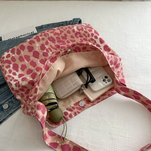 Pink leopard print canvas tote bag showing large capacity with umbrella and wallet inside