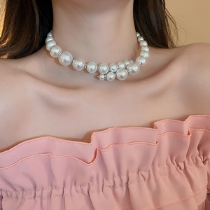 Close-up of elegant double-layered pearl necklace with varying sizes on a model
