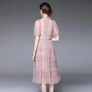 Vue arrière d'une robe rose en tulle et dentelle à volants avec manches bouffantes