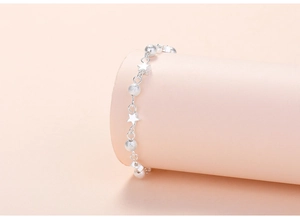 Detail of silver beaded bracelet with matte beads and star charms on a pink stand