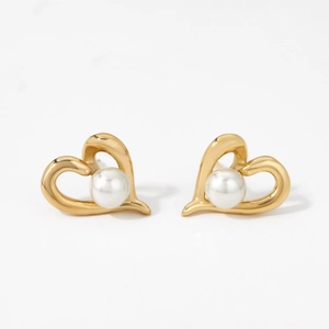 Elegant hollow heart-shaped earrings with white pearl center in gold finish on white background