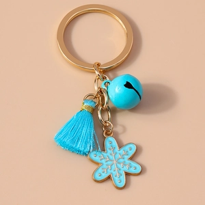 Detail of Christmas keychain with sky blue tassel, bell, and snowflake metal charm