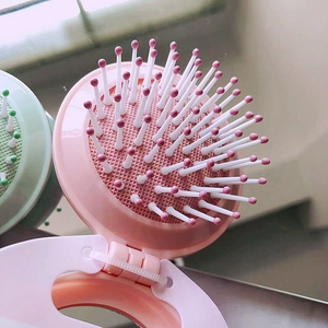 Portable pink and green folding mirror hair brush with massaging air cushion bristles
