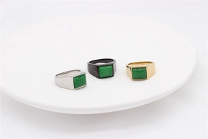 Detailed top view of retro square green gemstone rings in silver, black and gold steel